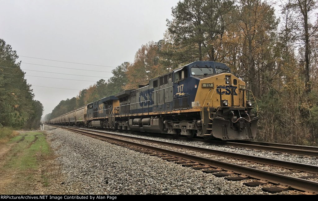 CSX 117 and 5465 wait for green with a line of covered hoppers